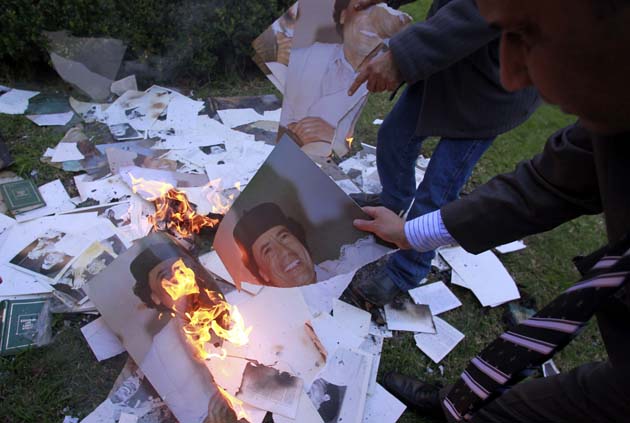 Employees of the Libyan Embassy burn portraits of Gaddafi in Buenos Aires